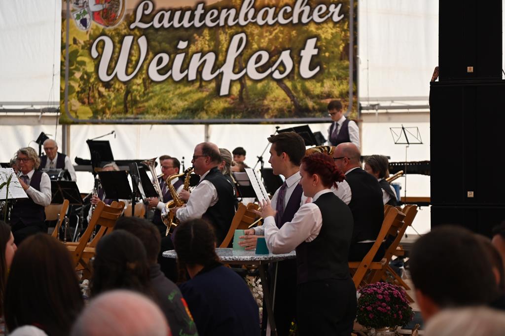 Rechter Halbkreis der MG Uttigen auf der Bühne. Im Hintergrund das Plakat vom Lautenbacher Weinfest.