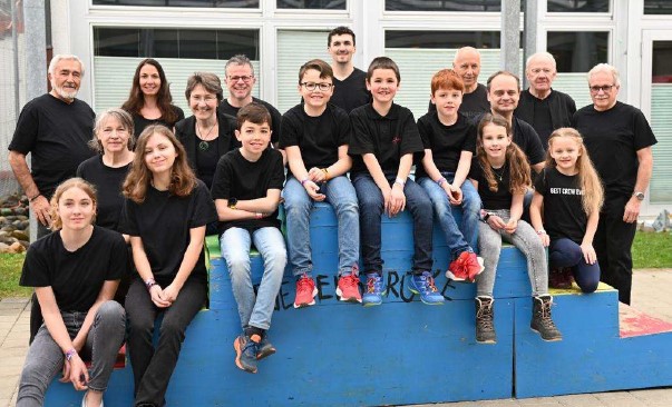 Projektteilnehmende auf der "Friedensbrücke" unter dem Baldachin beim Schulhaus Uttigen.