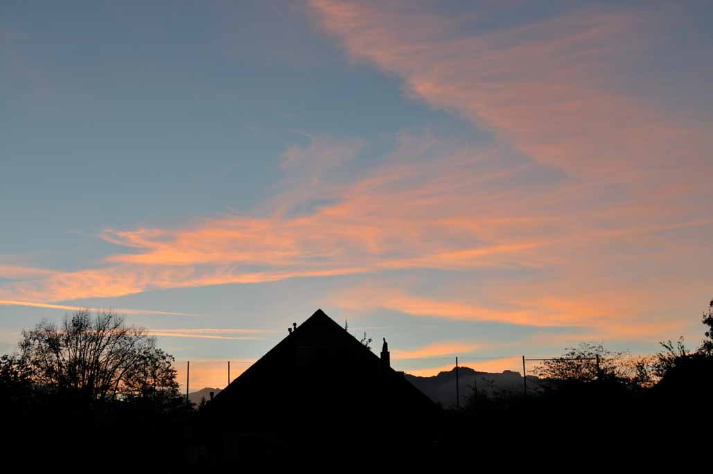 Morgenrot über den Dächern von Uttigen.