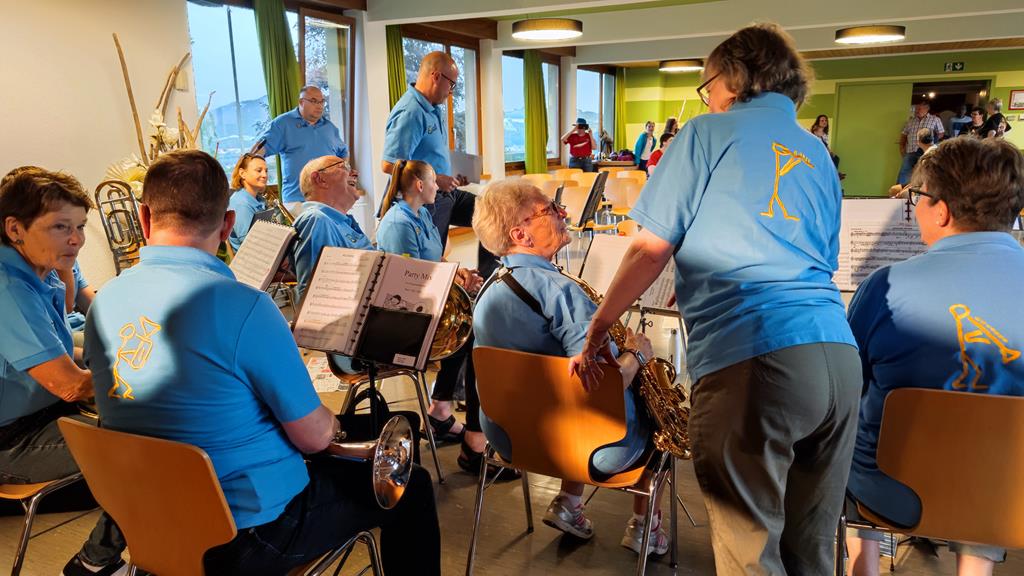 Die Musikanten sitzen und warten auf den Spielbeginn. (von hinten aufgenommen)