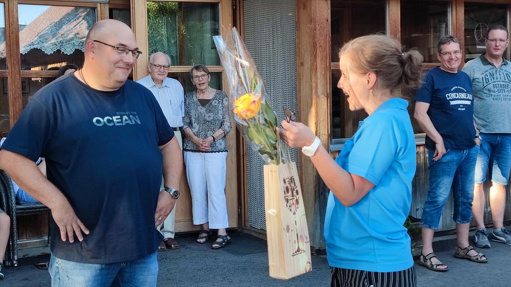 Dirigent Urs Hofmann bekommt von der Vizepräsidentin Claudia Zürcher ein Geschenk.